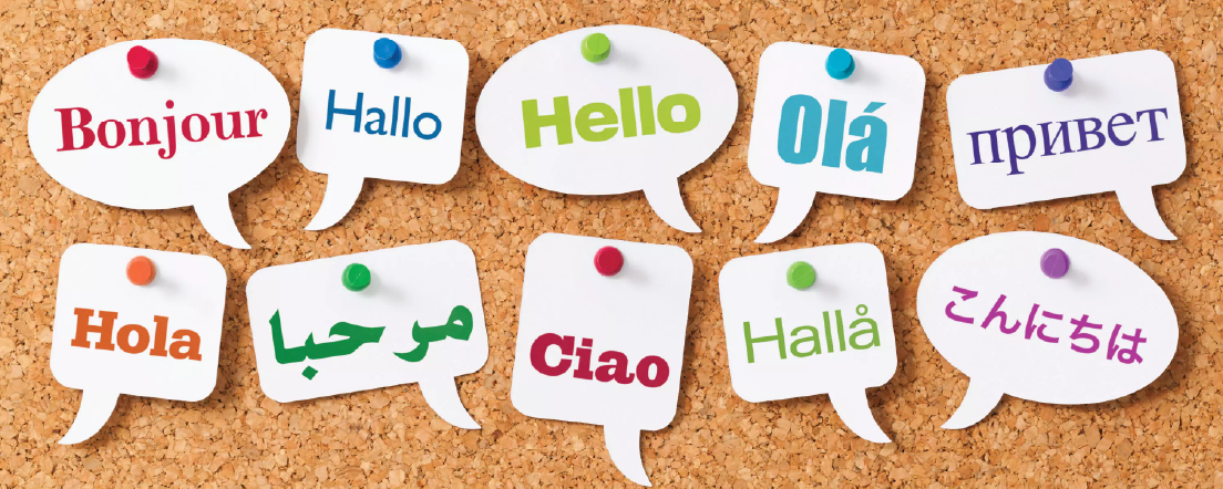 Un babillard affichant des salutations dans plusieurs langues, y compris en français, en anglais, et en espagnol (bonjour, holà, ola)