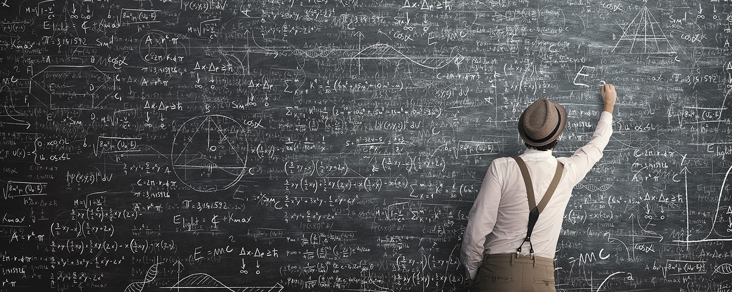 man calculating math equations on a chalk board